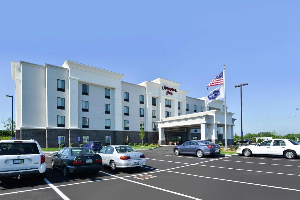 a hotel with cars parked in a parking lot at Hampton Inn Middletown in Middletown