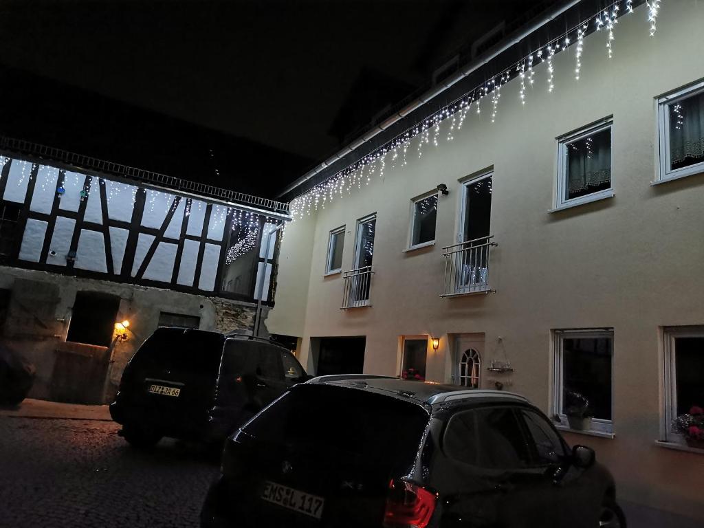 two cars parked in front of a building with christmas lights at Baldwin's Home Away from Home in Berndroth