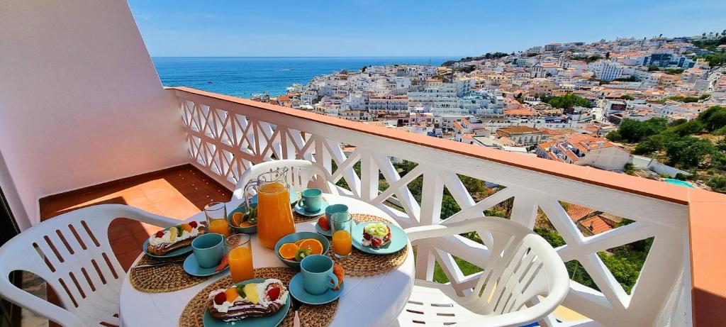 un tavolo con piatti di cibo in cima a un balcone di Albufeira Apart AE - Sea & Old Town View ad Albufeira