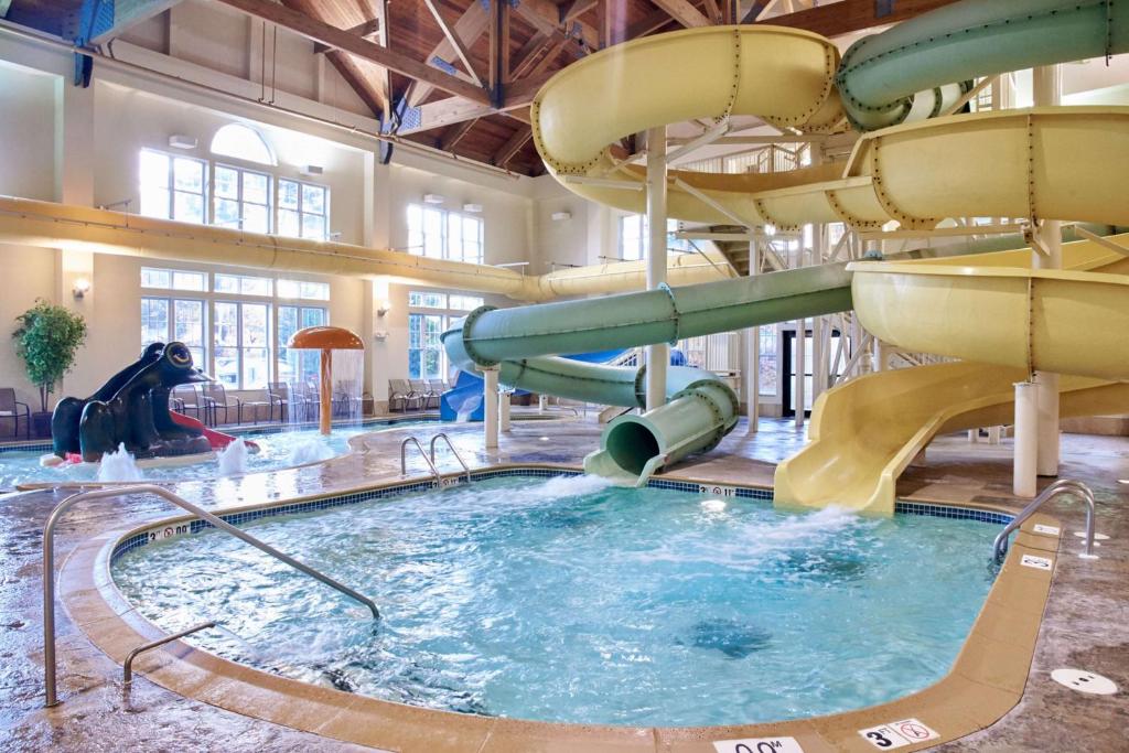 a large indoor swimming pool with a water slide at Hampton Inn & Suites North Conway in North Conway