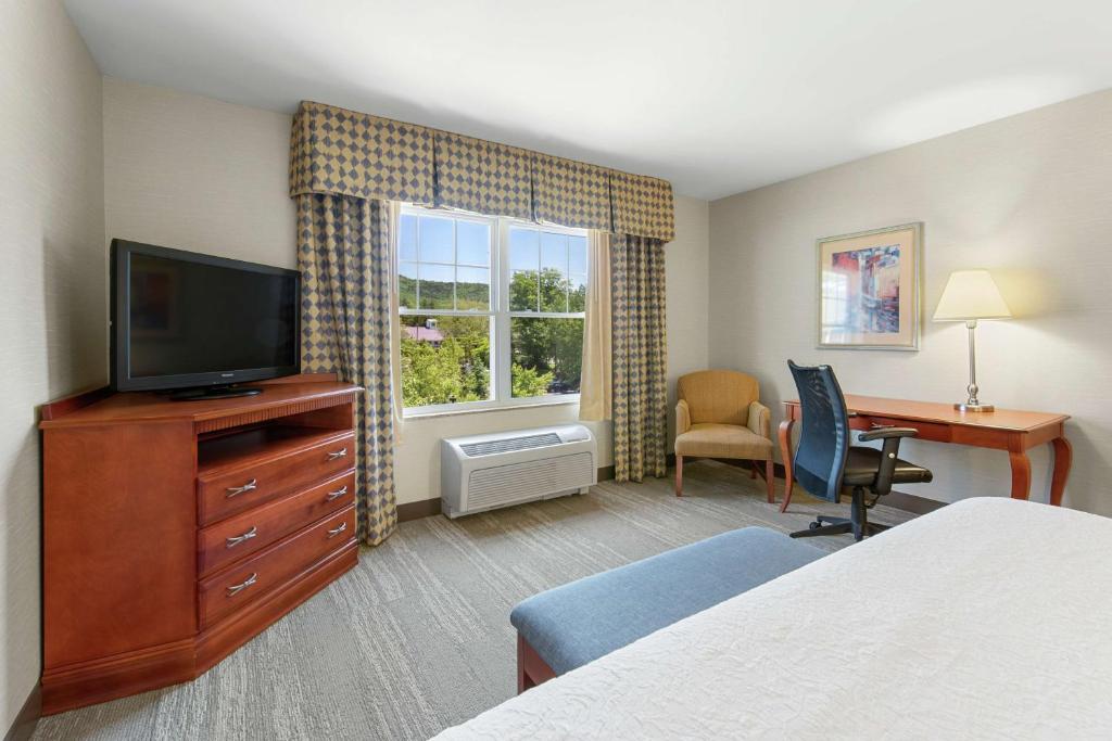a hotel room with a bed and a desk and a television at Hampton Inn & Suites North Conway in North Conway