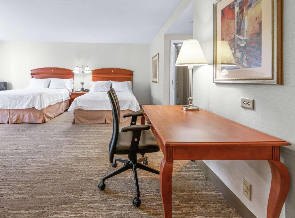a hotel room with a desk and a bed at Hampton Inn & Suites North Conway in North Conway
