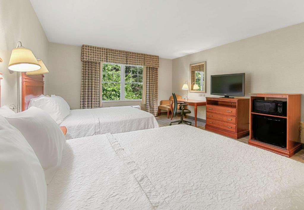 a hotel room with two beds and a flat screen tv at Hampton Inn & Suites North Conway in North Conway
