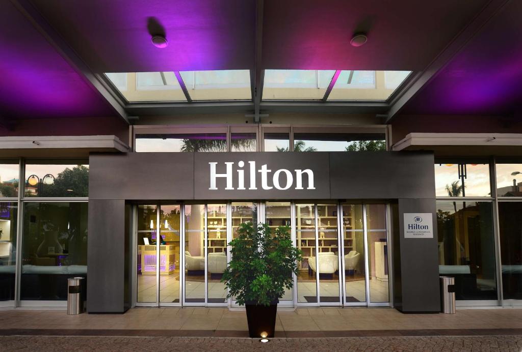 un bâtiment hilton avec une usine devant lui dans l'établissement Hilton Noumea La Promenade Residences, à Nouméa