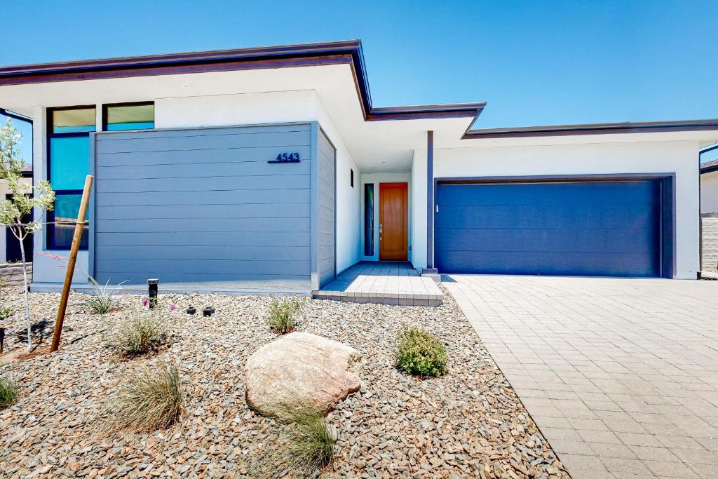 a white house with a blue garage door at Desert Oasis in Prescott Valley