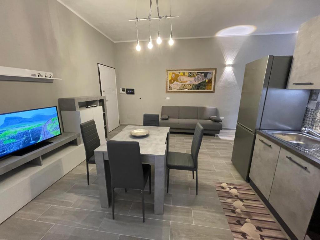 卡爾博尼亞的住宿－APPARTAMENTO ELEGANTE CARBONIA，厨房以及带桌子和电视的客厅。