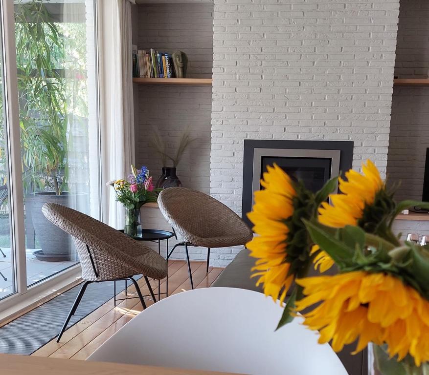 een woonkamer met een tafel en stoelen en een open haard bij Vakantiewoning De Papendaler in Zutendaal