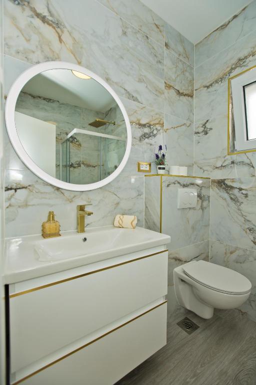 łazienka z umywalką, toaletą i lustrem w obiekcie Luxury Apartment Veronika w Hvarze