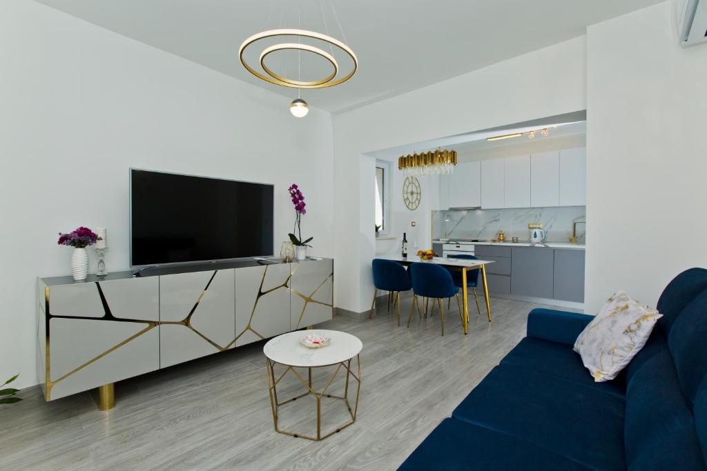 a living room with a blue couch and a kitchen at Luxury Apartment Veronika in Hvar