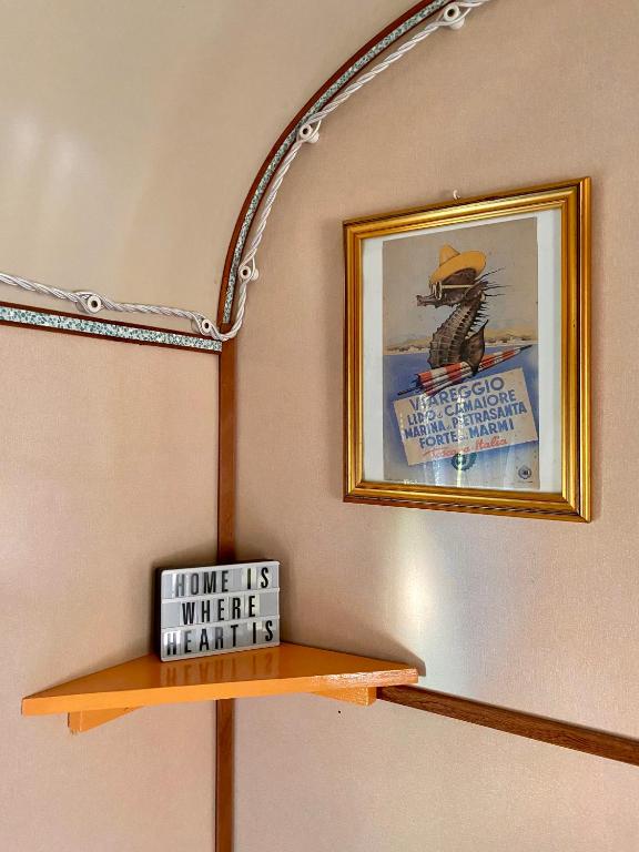 a shelf with a picture and a sign on a wall at Azienda agricola Della Mezzaluna in Stiava