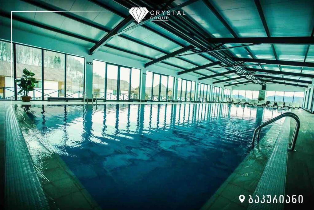 een groot zwembad met blauw water in een gebouw bij Crystal Loft 410 Bakuriani in Bakuriani