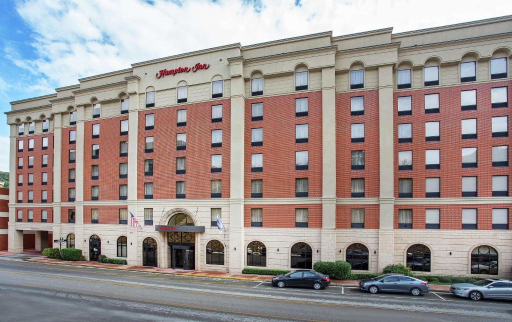 a large red brick building with cars parked in front of it at Hampton Inn Pikeville in Pikeville