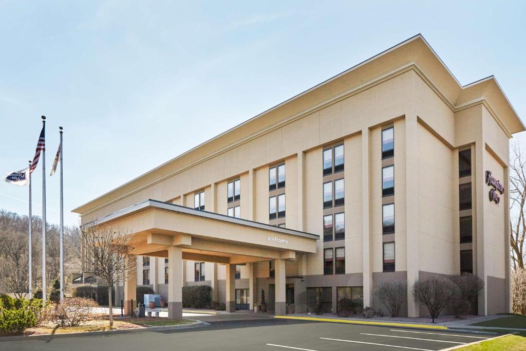 ein Bürogebäude mit Flaggen davor in der Unterkunft Hampton Inn East Peoria in Peoria