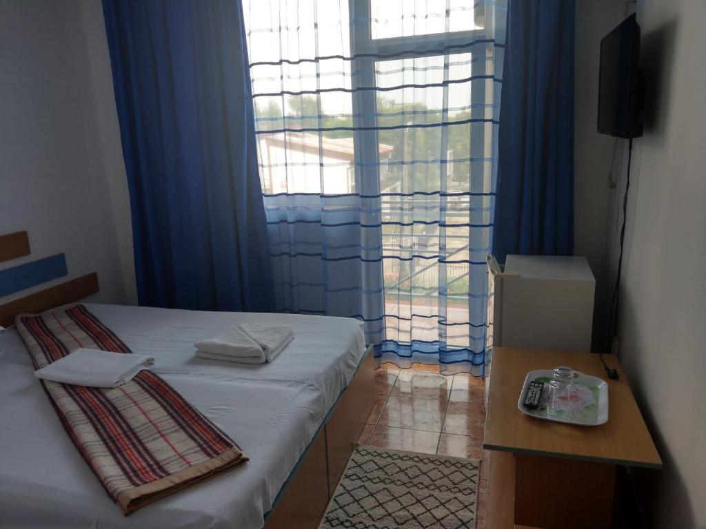 a bedroom with a bed and a large window at Hotel Vila Alex in Costinesti