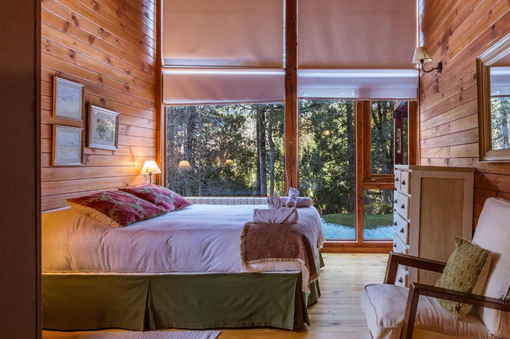 1 dormitorio con cama y ventana grande en BOG Las Lomitas en Villa La Angostura