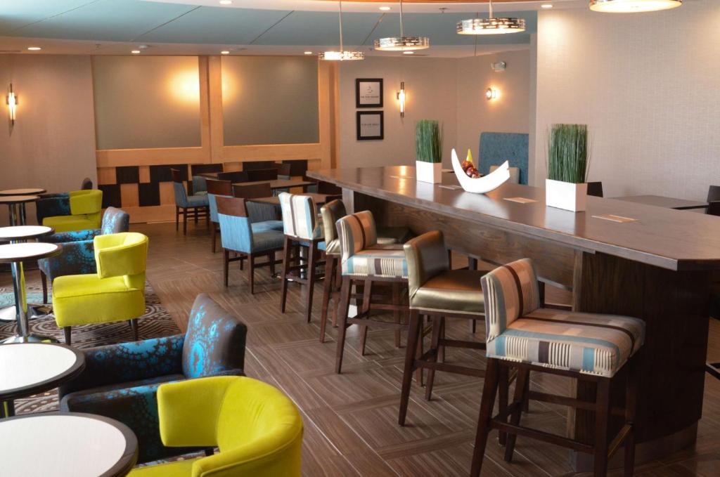 um bar num restaurante com cadeiras e mesas coloridas em Hampton Inn Perry em Perry