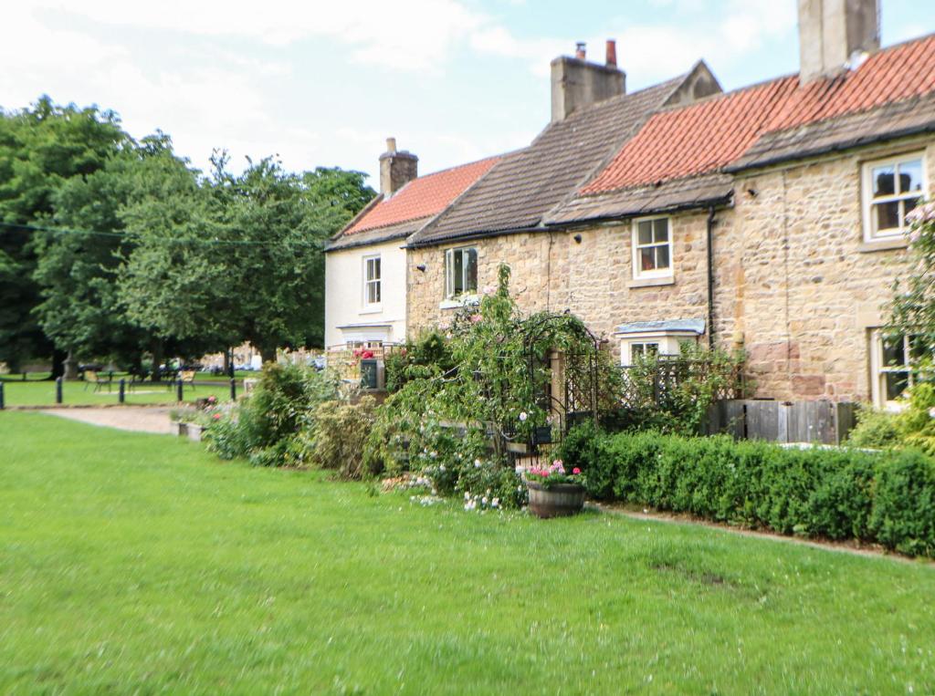 an old brick house with a green yard at Sunny Cottage in Darlington