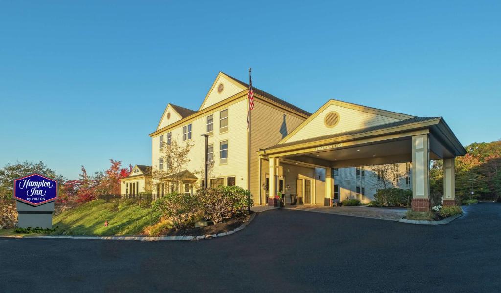 una gran casa amarilla con un cartel delante en Hampton Inn Freeport&#47;Brunswick, en Freeport