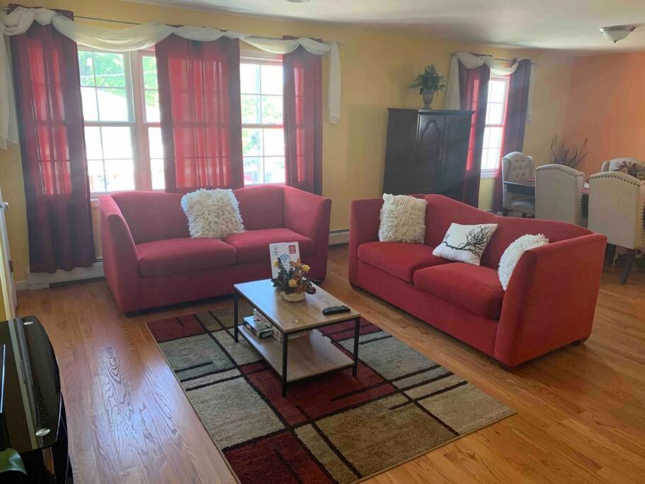 a living room with two red couches and a coffee table at Family 3-bedroom home (2nd floor near EWR/Outlet) in Elizabeth