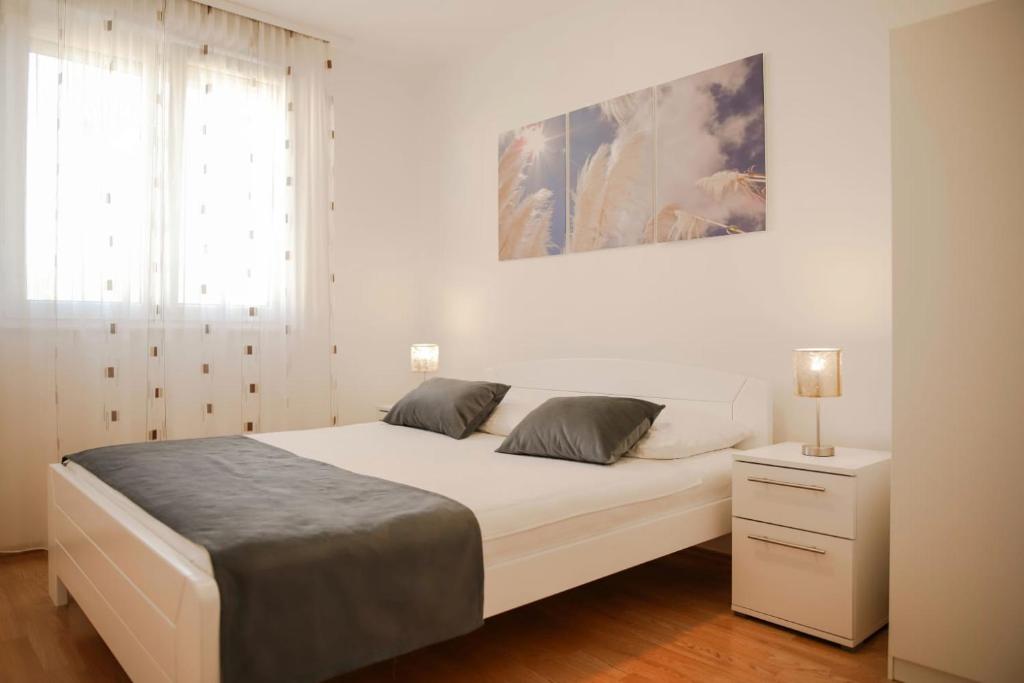 um quarto branco com uma cama grande e uma janela em Penthouse Panorama em Capljina