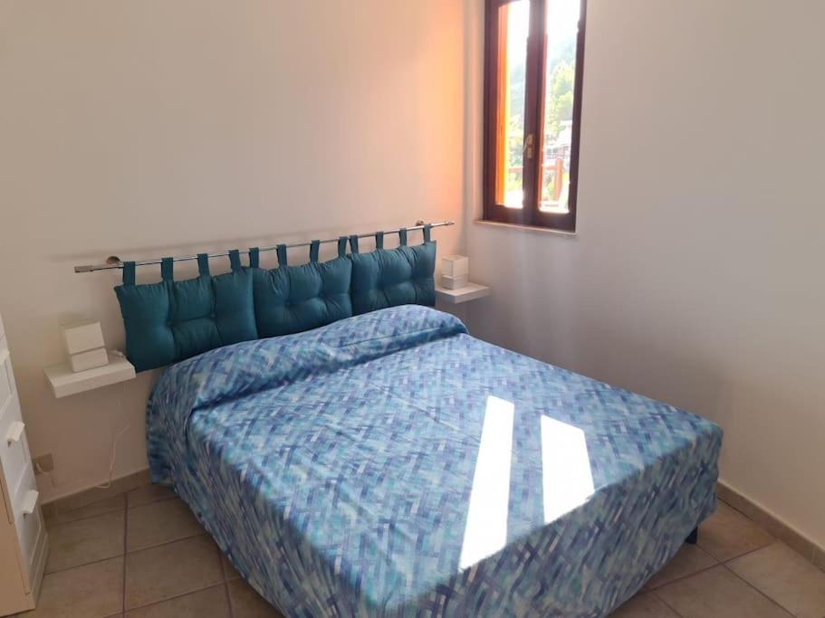 a bedroom with a bed with a blue comforter at Un Tuffo nel Blu in Sperlonga