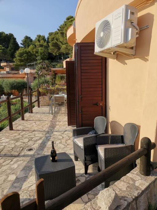 a patio with chairs and tables and a building at Un Tuffo nel Blu in Sperlonga