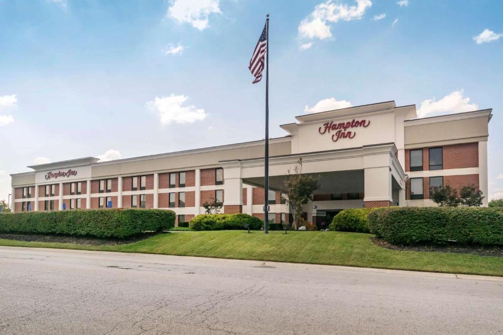 un edificio de oficinas con una bandera americana delante de él en Hampton Inn Richmond KY, en Richmond