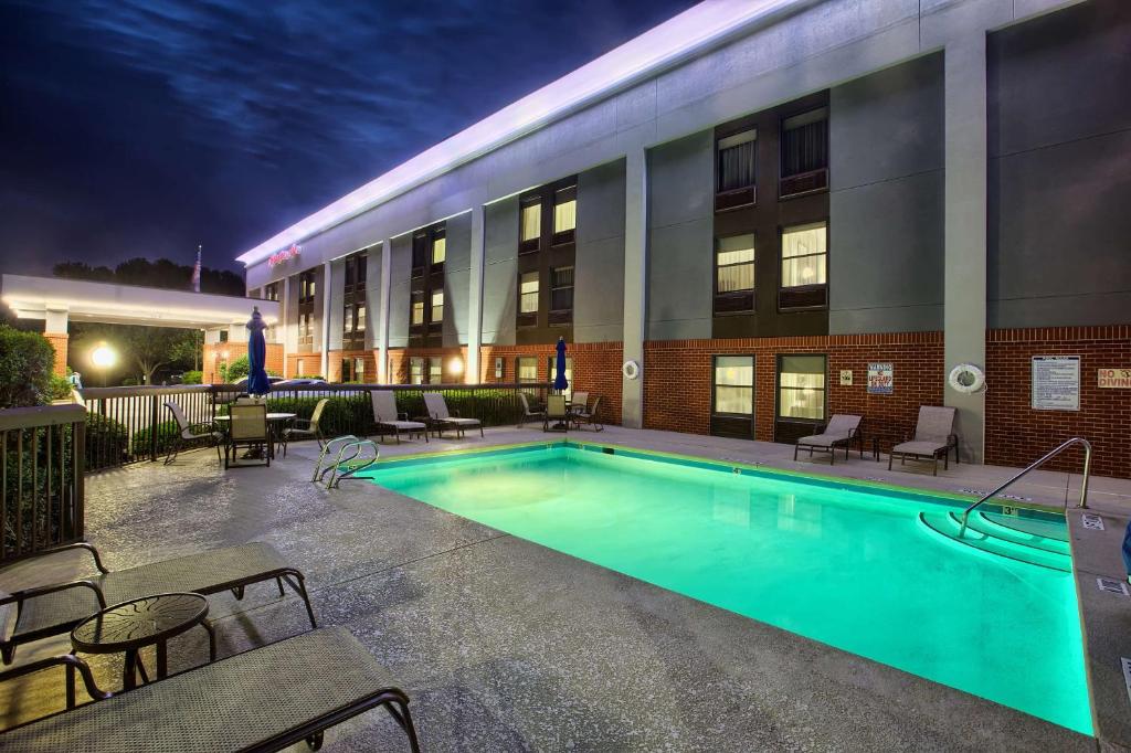 a pool in front of a hotel at night at Hampton Inn Raleigh/Garner in Garner