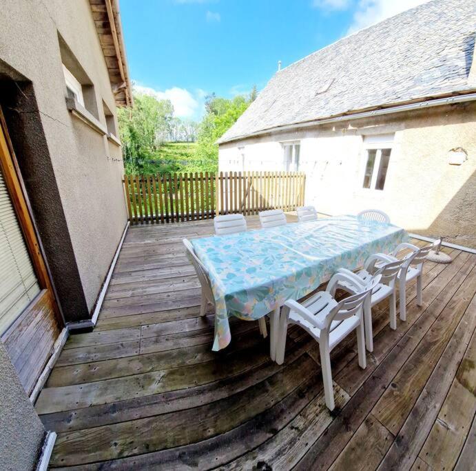 a table and chairs on a wooden deck at Gîte La Scierie, Maison Familiale, Laguiole in Laguiole
