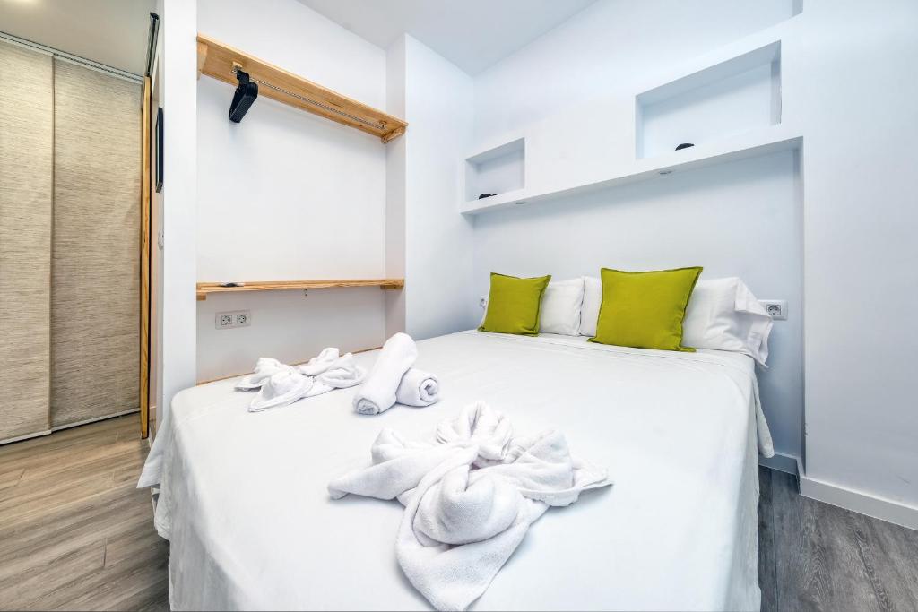 um quarto com uma cama branca e toalhas em Studio El Greco near the Reducto beach em Arrecife