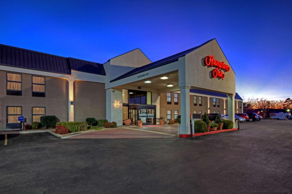 a front view of a hotel with a dinosaur sign on it at Hampton Inn Russellville in Russellville