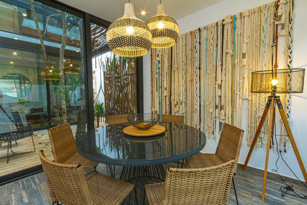 Un comedor con una mesa de cristal y sillas. en Amazing 3Br & Private Patio With Pool in Mun 32 Tulum, en Tulum