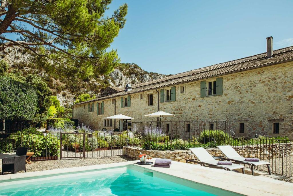 une maison avec une piscine en face d'un bâtiment dans l'établissement Maison CHENET - Les Chambres Entre Vigne et Garrigue - Teritoria, à Pujaut