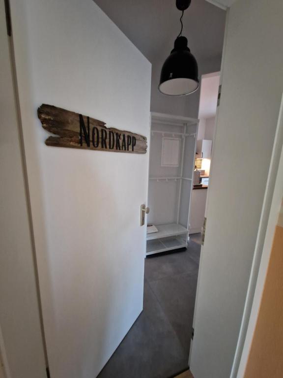 um quarto com uma porta com um sinal em FeWo NORDKAPP em Warnemünde