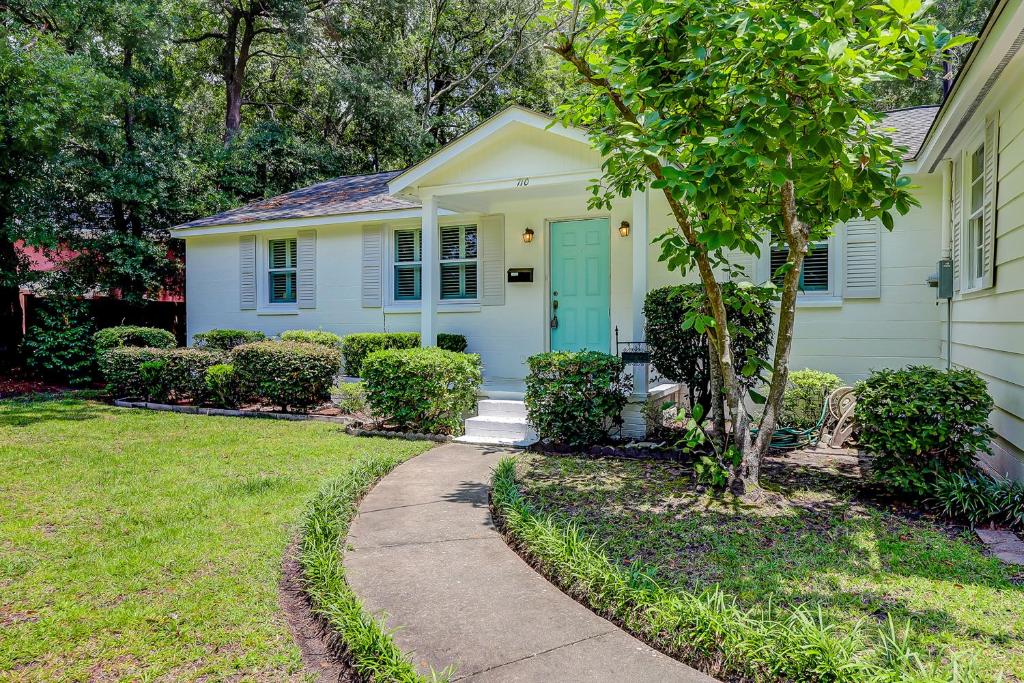 une maison blanche avec une porte bleue et un trottoir dans l'établissement Live Like a Local, à Charleston