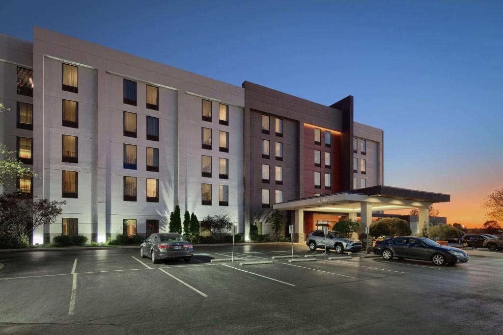 a large building with cars parked in a parking lot at Hampton Inn Louisville Northeast in Louisville
