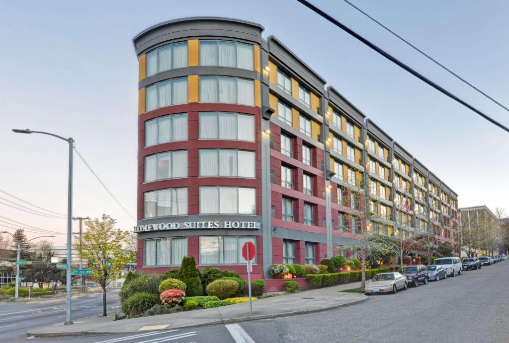 a red building on a street with cars parked outside at Homewood Suites by Hilton Seattle Downtown in Seattle