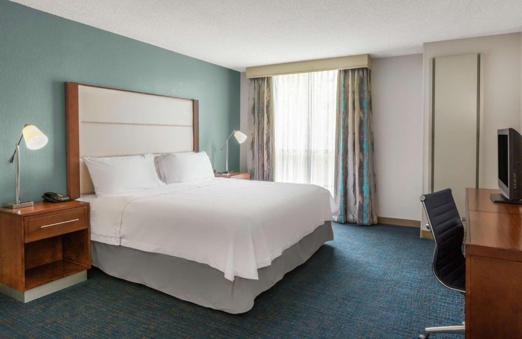 a hotel room with a large bed and a television at Homewood Suites by Hilton Seattle Downtown in Seattle