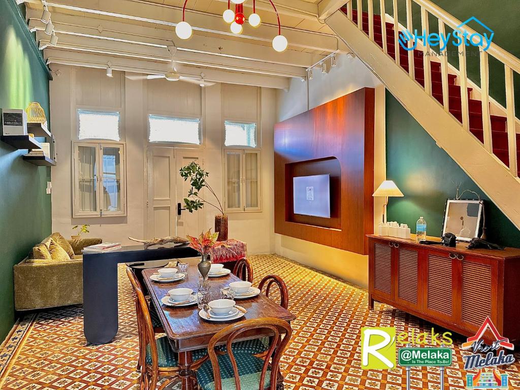 a living room with a table and a staircase at JonkerHeritage House WalkingDistance10minsJonker By Heystay Management in Melaka