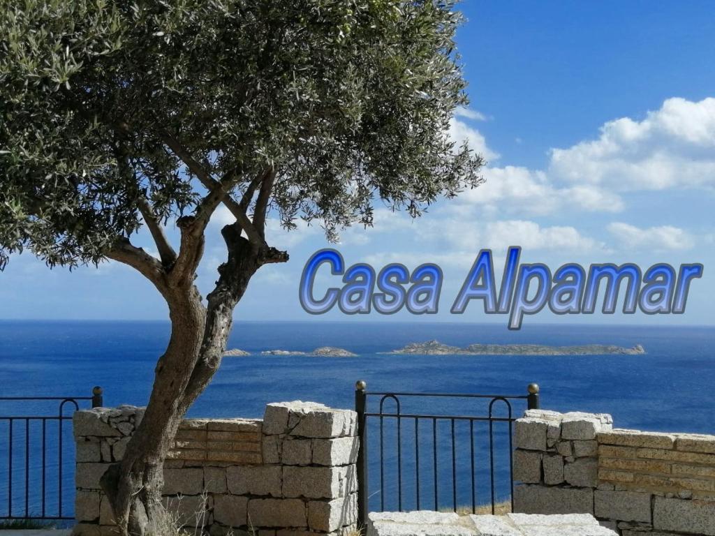 a tree in front of a fence with the sign for casa aaron at Casa Alpamar in Villasimius