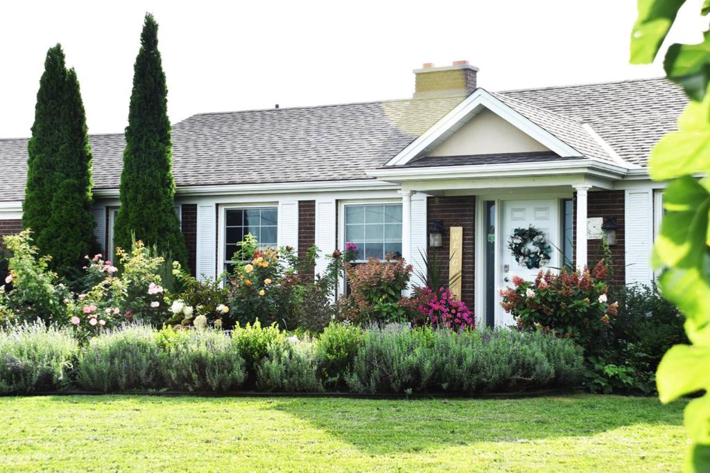 ein Haus mit Blumen im Vorgarten in der Unterkunft As You Like It Bed and Breakfast in Niagara on the Lake