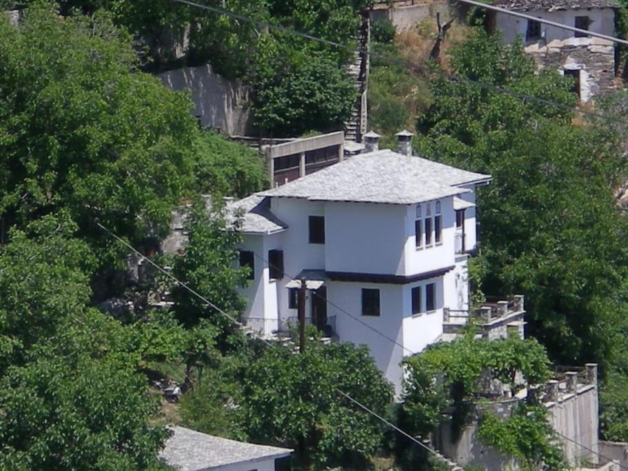 a white house on the side of a hill at Άνετος χώρος με parking, αυλή και θαυμάσια θέα in Makrinítsa