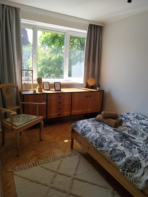 a bedroom with a bed and a dresser and a window at Apartament nad morzem Sopot in Sopot