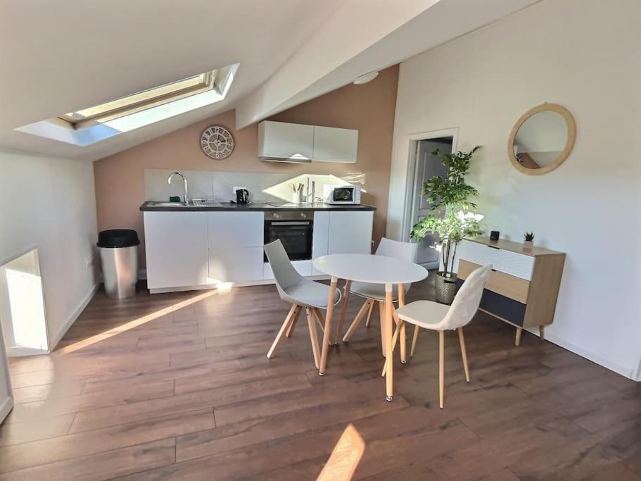 een keuken en eetkamer met een tafel en stoelen bij Le Saint-Quentin in Longeville-lès-Metz