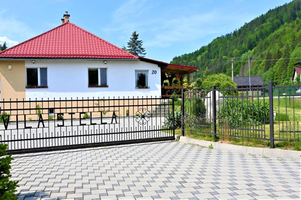 a black fence in front of a white house at VILA Stella in Bystrá
