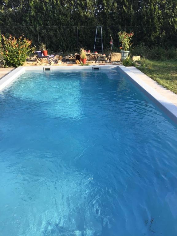 una gran piscina con agua azul en un patio en Partie de mas en campagne, en Cavaillon