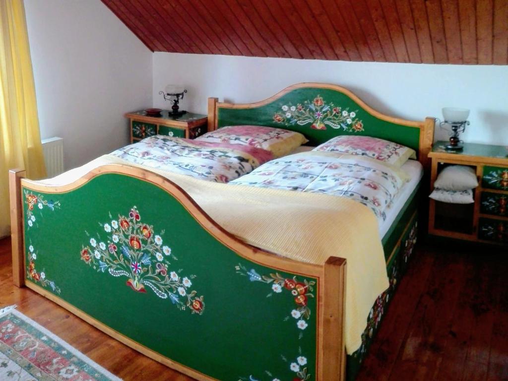 una camera da letto con un letto verde con sopra dei fiori di Boutique apartment 80 sqm a Porumbacu de Sus