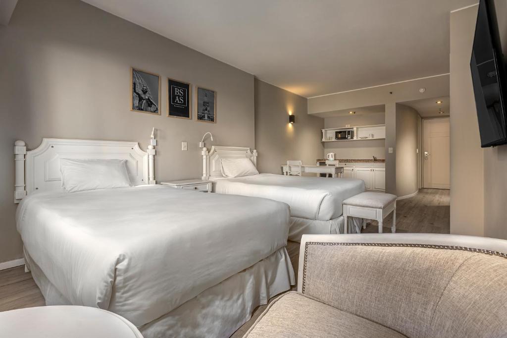 a hotel room with two beds and a table and chairs at Up América Plaza in Buenos Aires