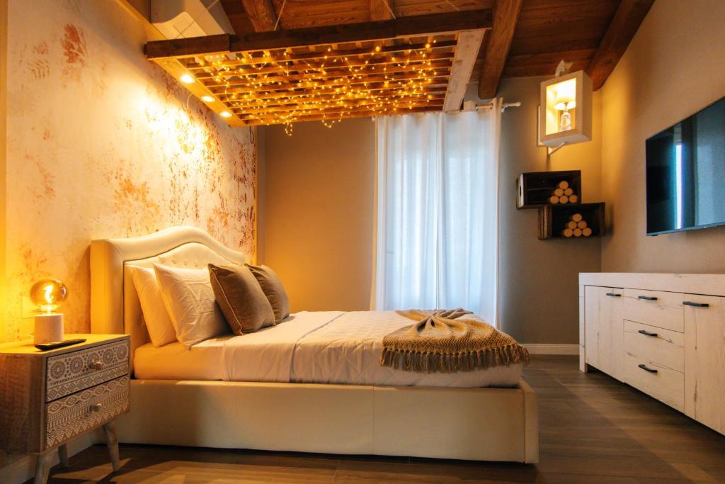 a bedroom with a bed with a chandelier on the ceiling at Agriturismo Agli ulivi in Saluzzo