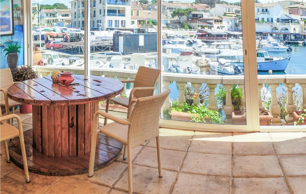 een tafel en stoelen op een balkon met een jachthaven bij Nice Home In Sausset-les-pins With Kitchen in Sausset-les-Pins